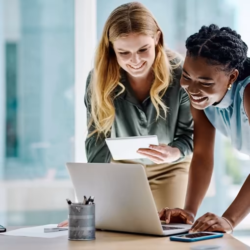 Zwei Frauen nehmen gemeinsam an einem interaktiven KI-Online-Workshop am Laptop teil.